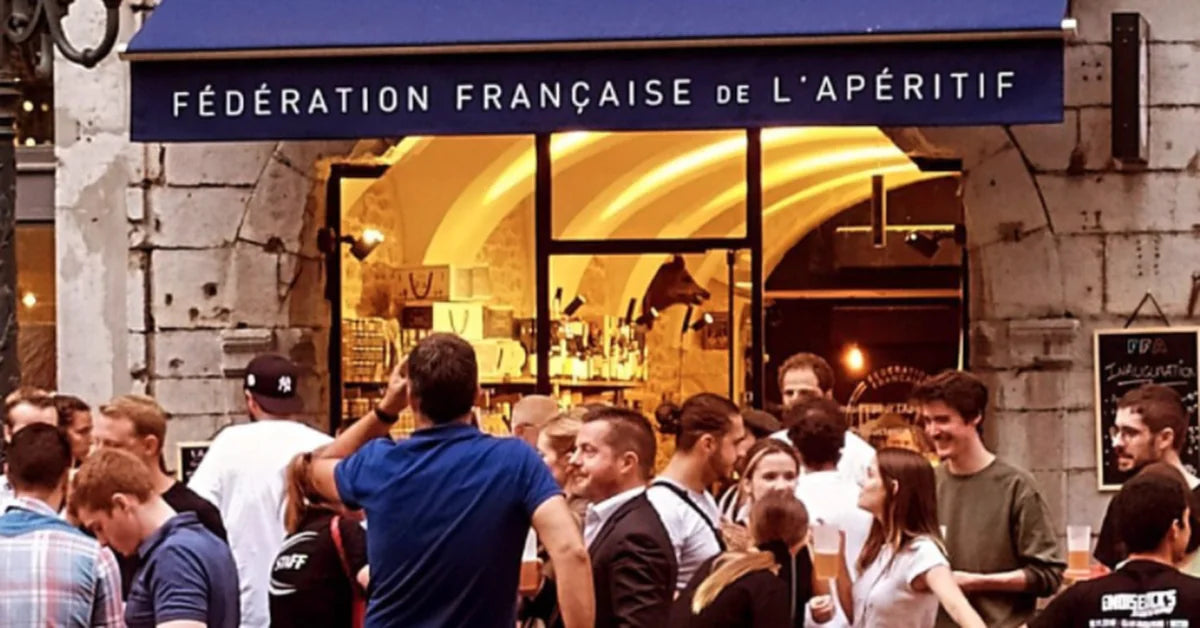 Devanture de la Fédération Française de l’Apéritif avec une foule conviviale en terrasse, ambiance chaleureuse en soirée