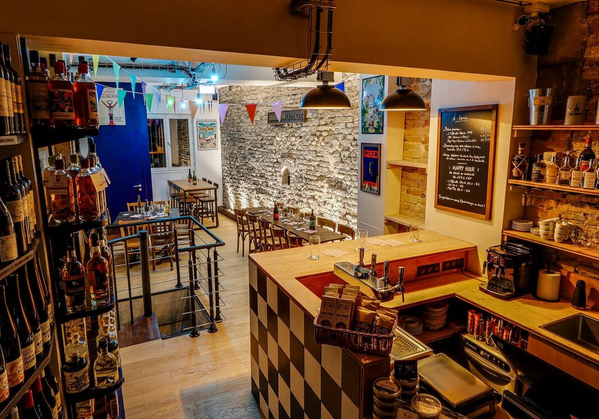 Intérieur du bar de la Fédération Française de l’Apéritif avec étagères de vins et spiritueux, comptoir en bois et ambiance chaleureuse.