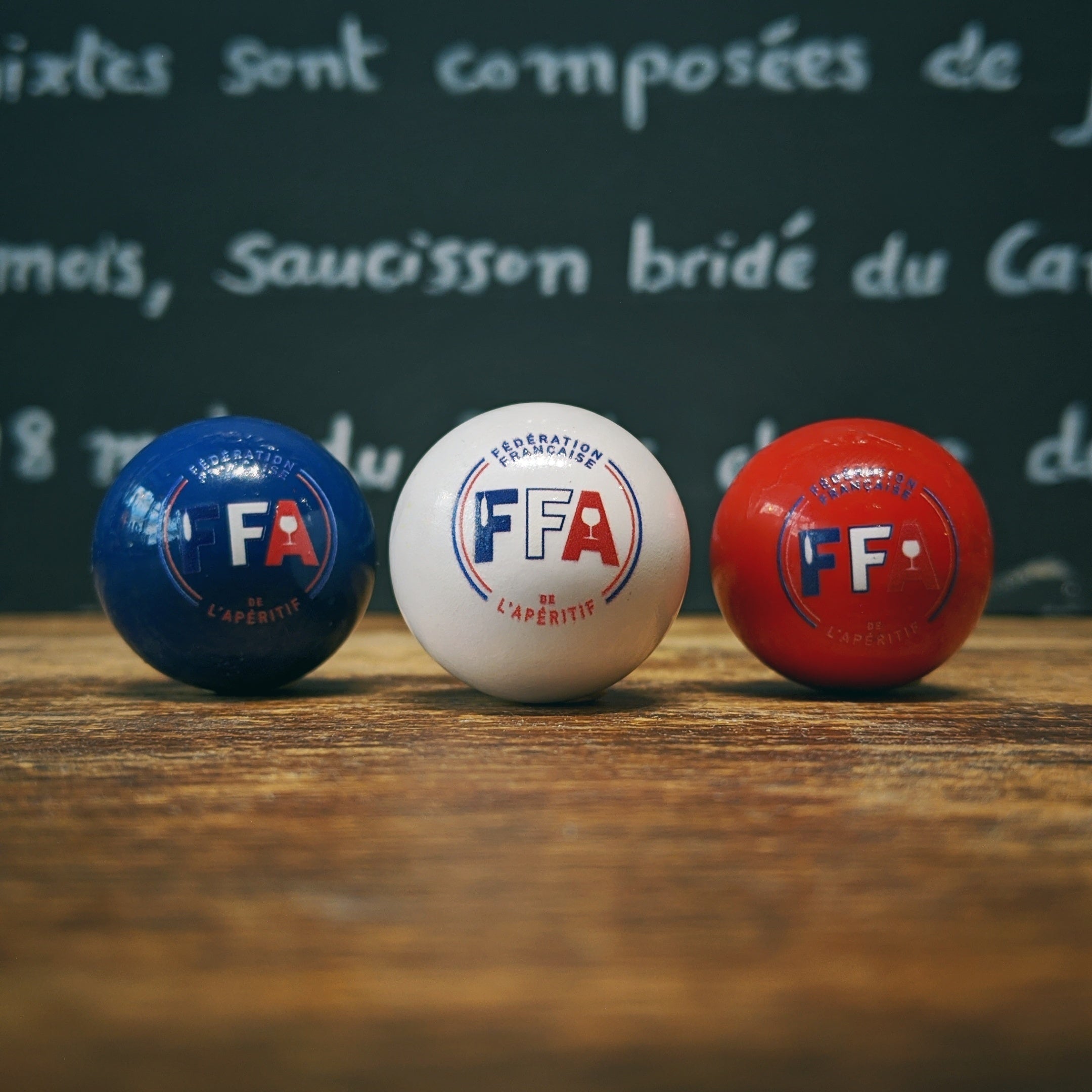 Cochonnets tricolores FFA en bois de buis fabriqués en France, accessoires officiels de pétanque et d’apéritif.