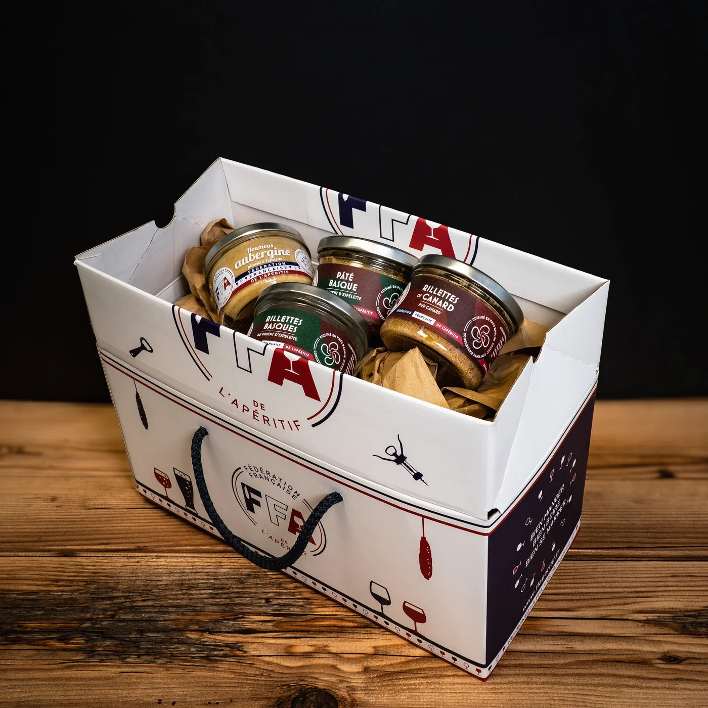 Coffret apéritif du Sud-Ouest de la Fédération Française de l’Apéritif — rillettes de canard, pâté basque, houmous d’aubergine et rillettes basques dans un coffret FFA illustré, ambiance conviviale et gourmande du Sud-Ouest.