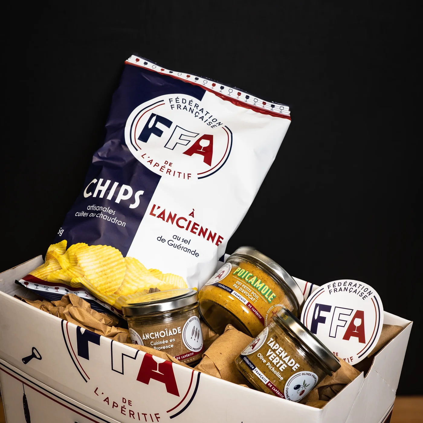 Coffret apéritif gourmand de la Fédération Française de l’Apéritif avec chips à l’ancienne au sel de Guérande, anchoïade, tapenade verte et poicamole — présentation soignée et ambiance conviviale.