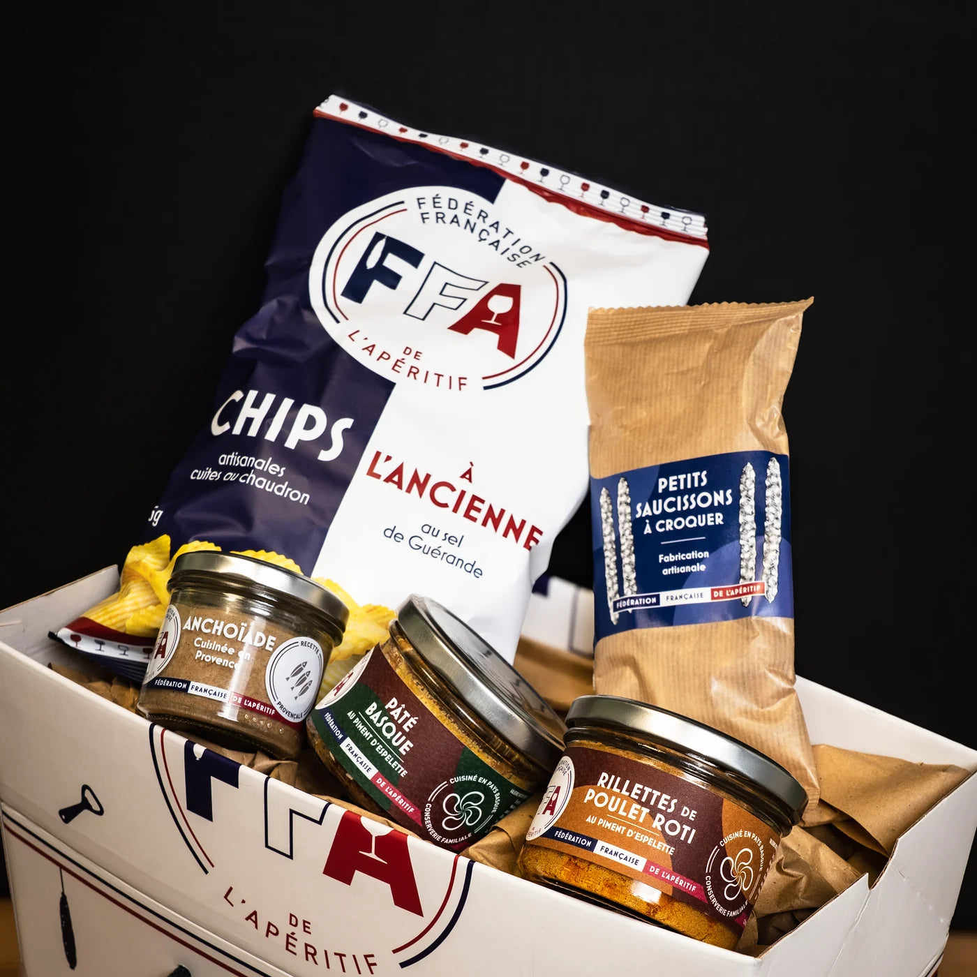 Coffret apéritif de la Fédération Française de l’Apéritif avec chips à l’ancienne, petits saucissons à croquer, pâté basque, anchoïade et rillettes de poulet rôti — sélection artisanale pour un apéro convivial et gourmand.