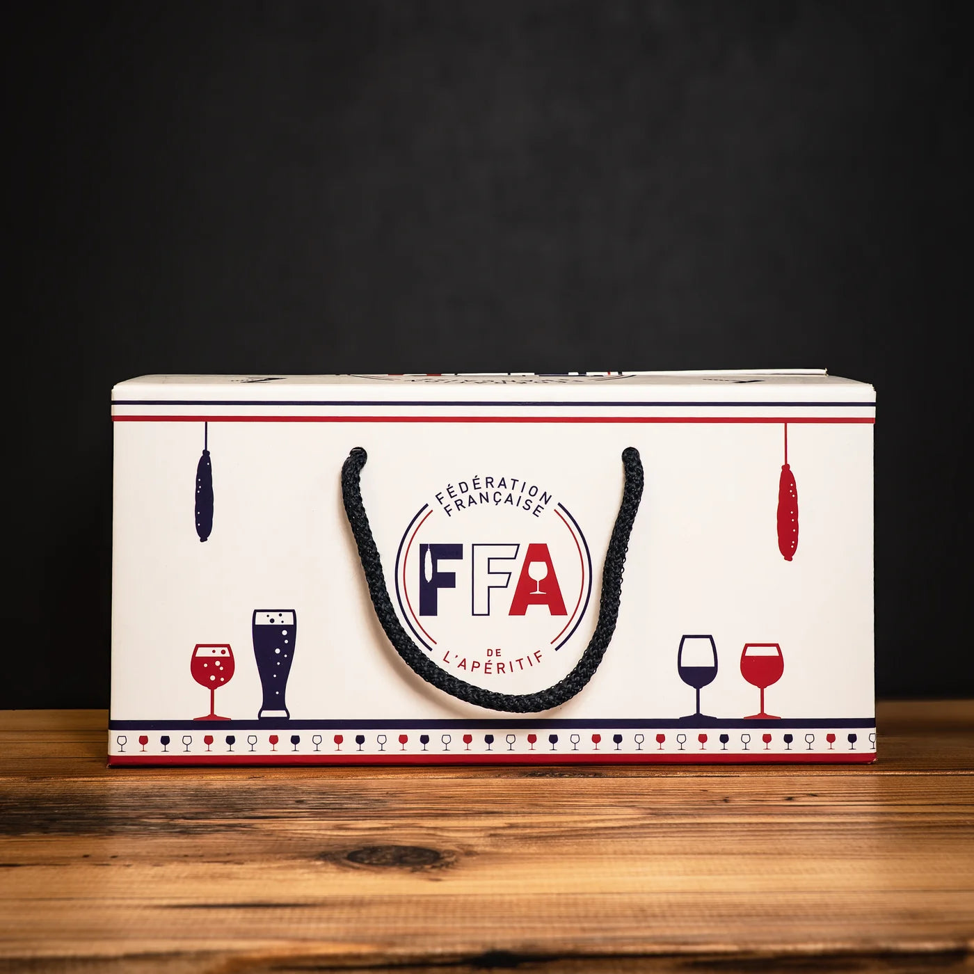 Grand coffret cadeau FFA en carton blanc avec poignée tressée et motifs apéritifs bleu blanc rouge — Fédération Française de l’Apéritif.