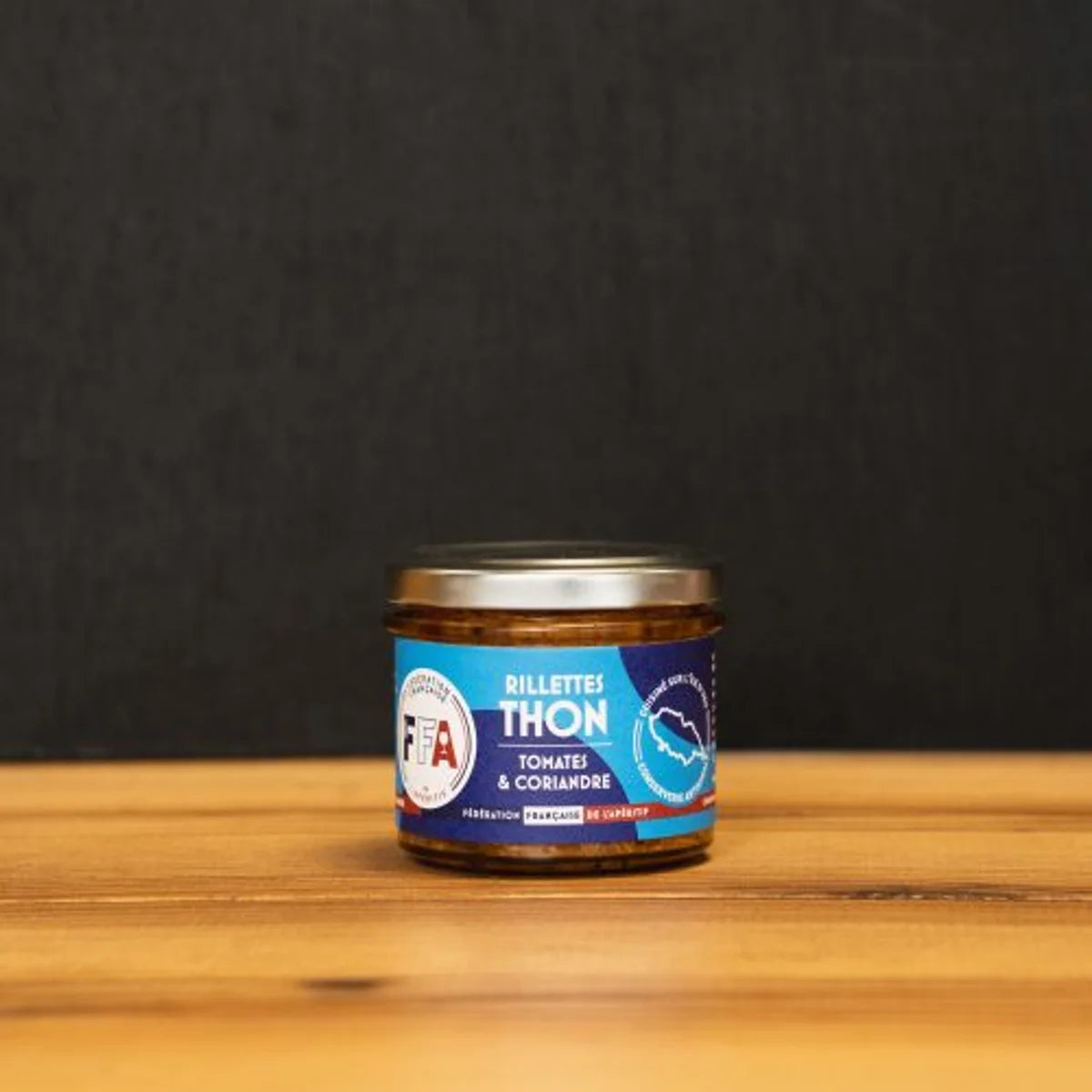 Rillettes de thon à la tomate et coriandre artisanales FFA, cuisinées sur l’île d’Yeu et présentées dans un bocal sur planche en bois pour l’apéritif.