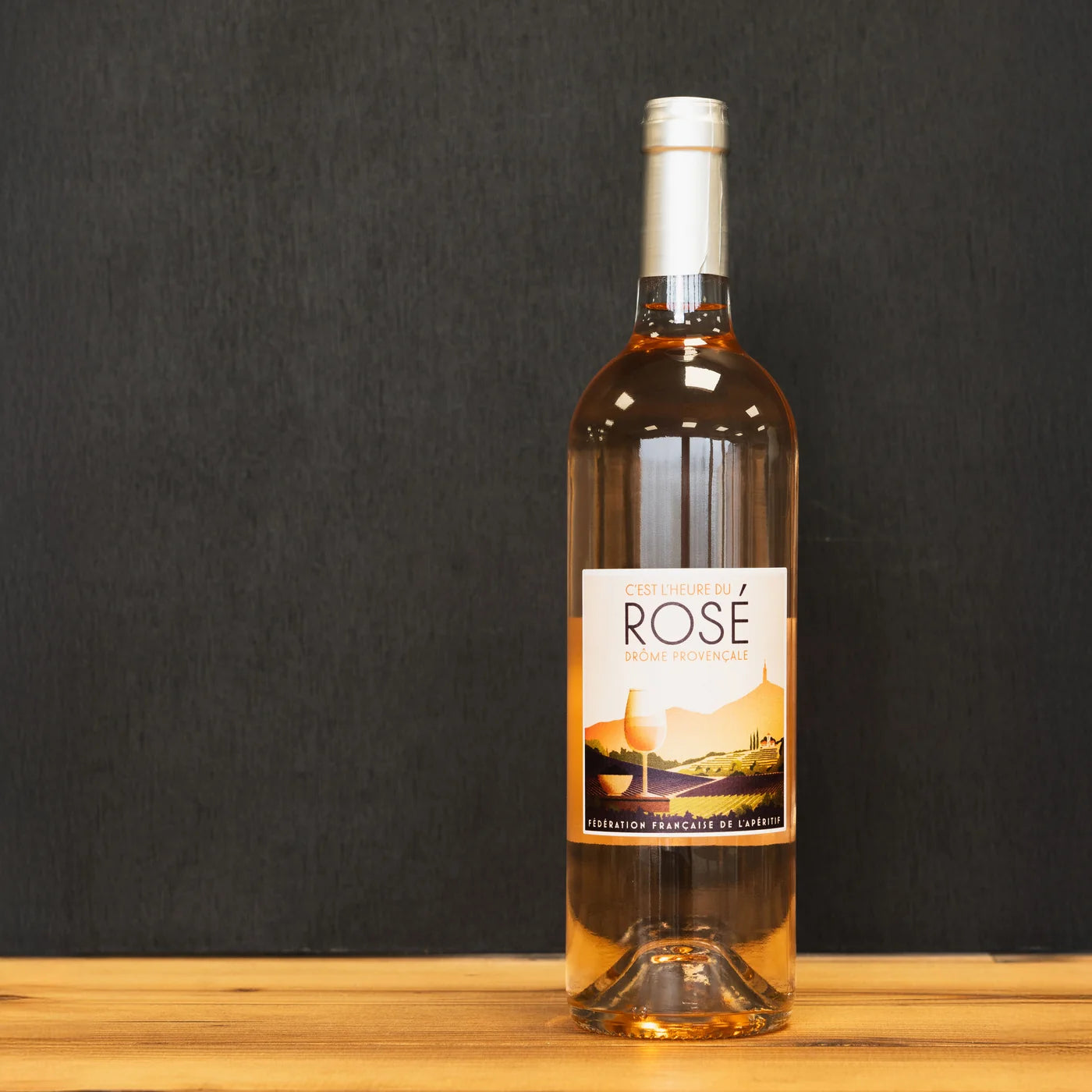 Bouteille de rosé C’est l’heure du Rosé – Drôme Provençale, signée Fédération Française de l’Apéritif, posée sur un comptoir en bois clair — un vin frais et convivial pour l’apéritif.