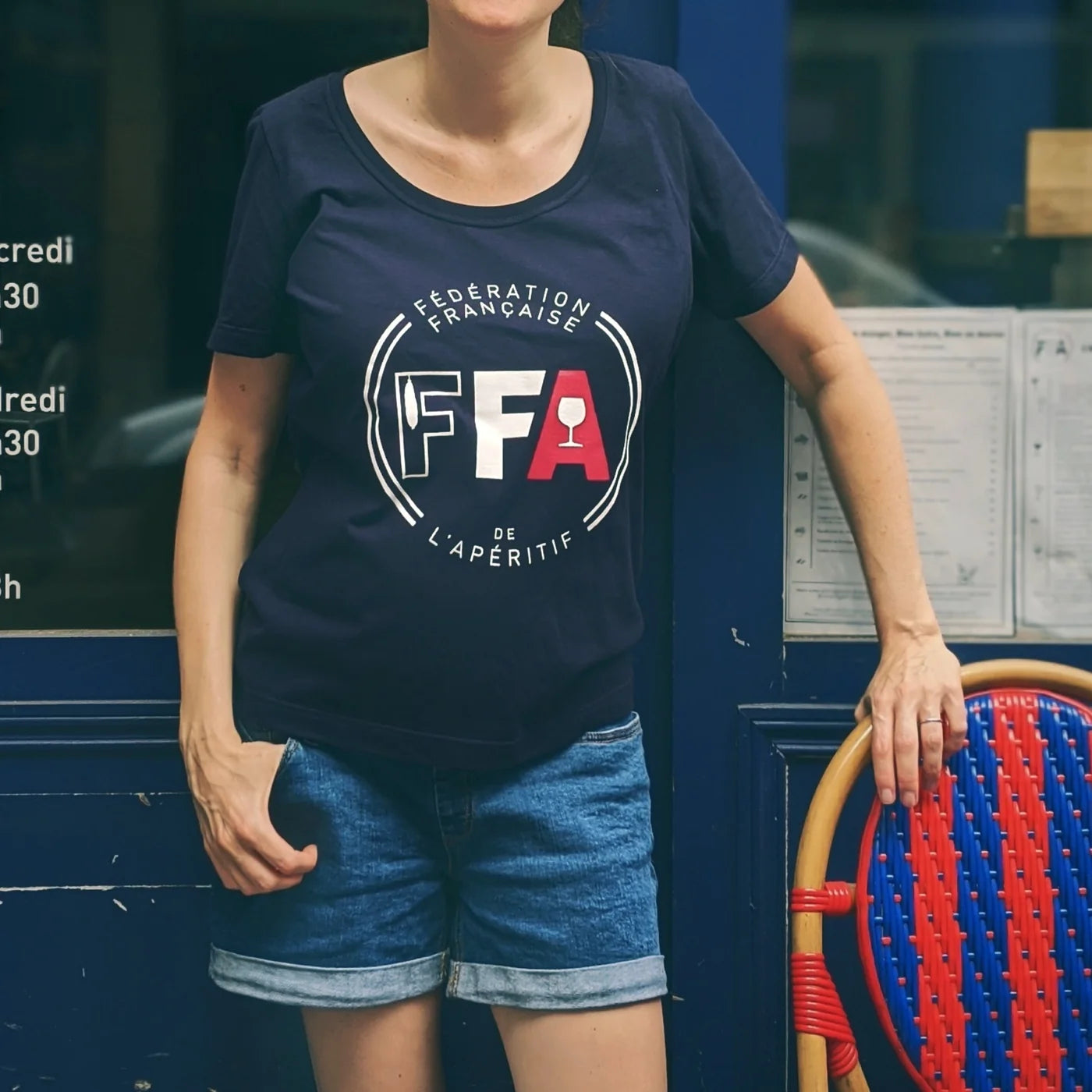 T-shirt bleu marine Fédération Française de l’Apéritif porté en terrasse — coupe décontractée, logo FFA blanc et rouge, ambiance conviviale et estivale typique des apéros français.