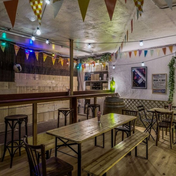 Espace bar de la boutique FFA décoré pour l’apéritif, ambiance conviviale avec guirlandes, terrain de pétanque et tables en bois.