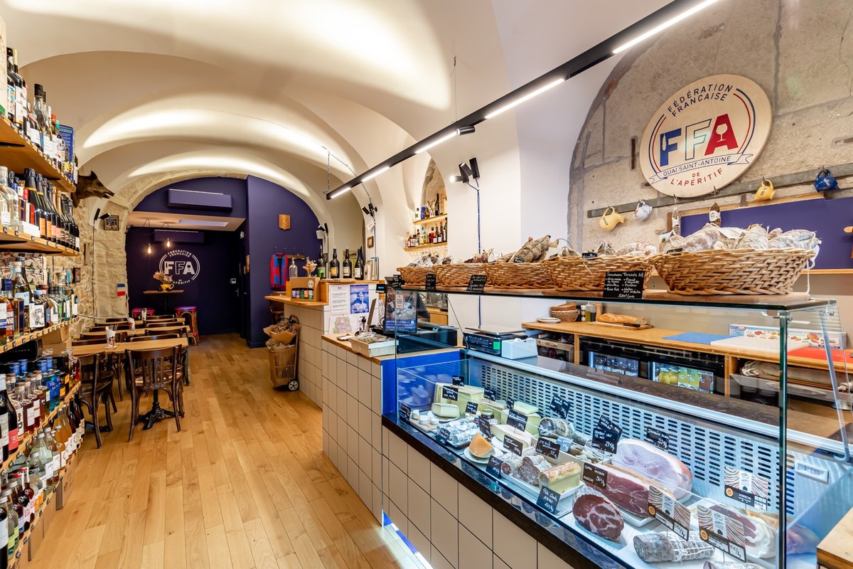 Intérieur d'une boutique FFA avec comptoir de fromages, charcuteries artisanales et cave à vins.
