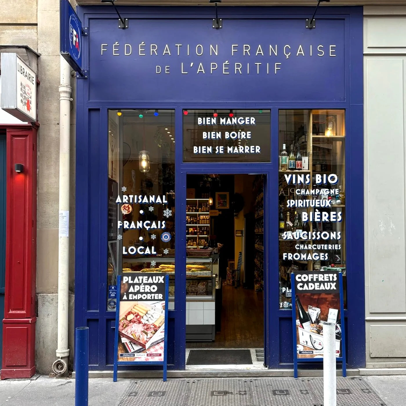 Façade de la boutique Fédération Française de l’Apéritif à Paris — vitrine bleue, affichages apéritifs et ambiance artisanale et conviviale.
