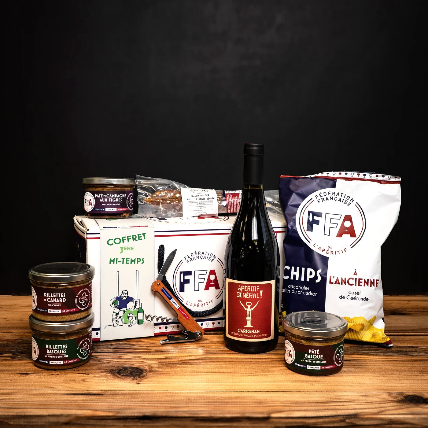Coffret apéritif FFA “3e mi-temps” entouré de produits artisanaux — rillettes, pâté, chips, vin et saucisson, ambiance conviviale et sportive.