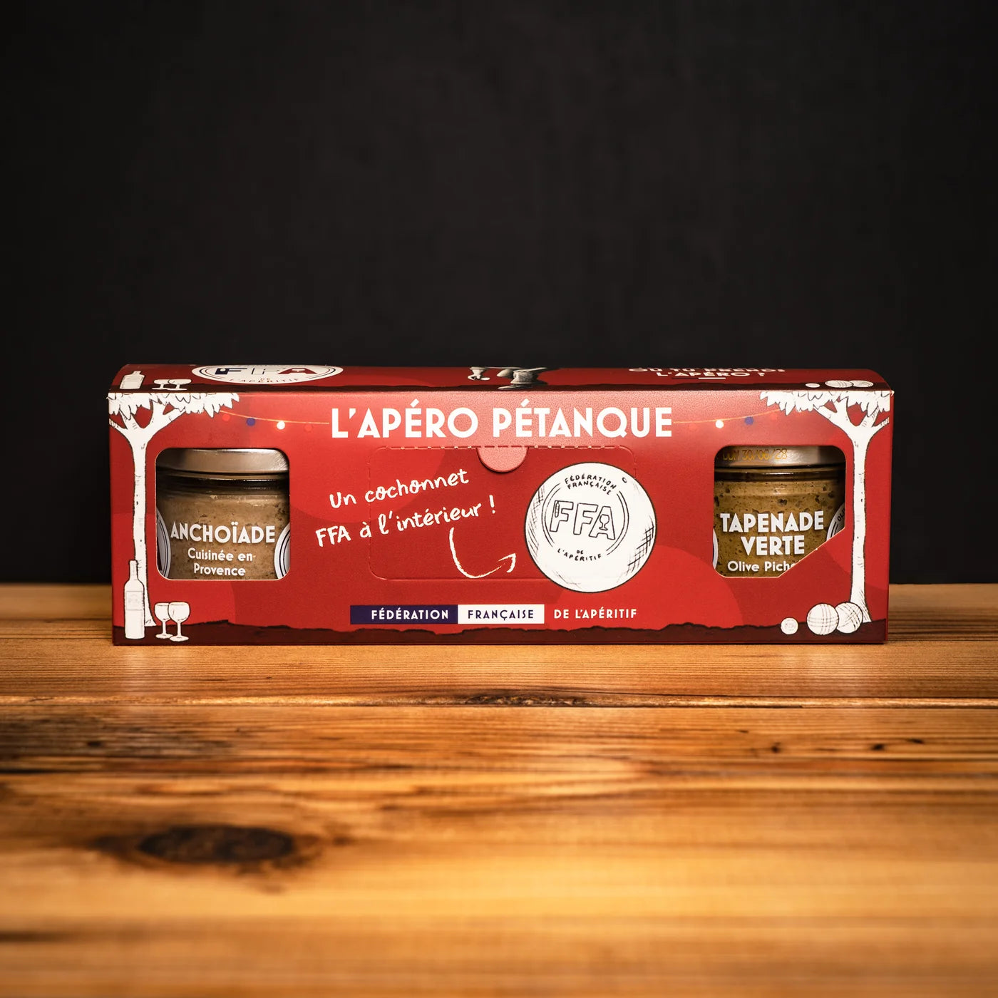 Coffret L’Apéro Pétanque FFA avec anchoïade et tapenade verte, présenté sur une table en bois — coffret gourmand et festif pour un apéritif à la provençale.