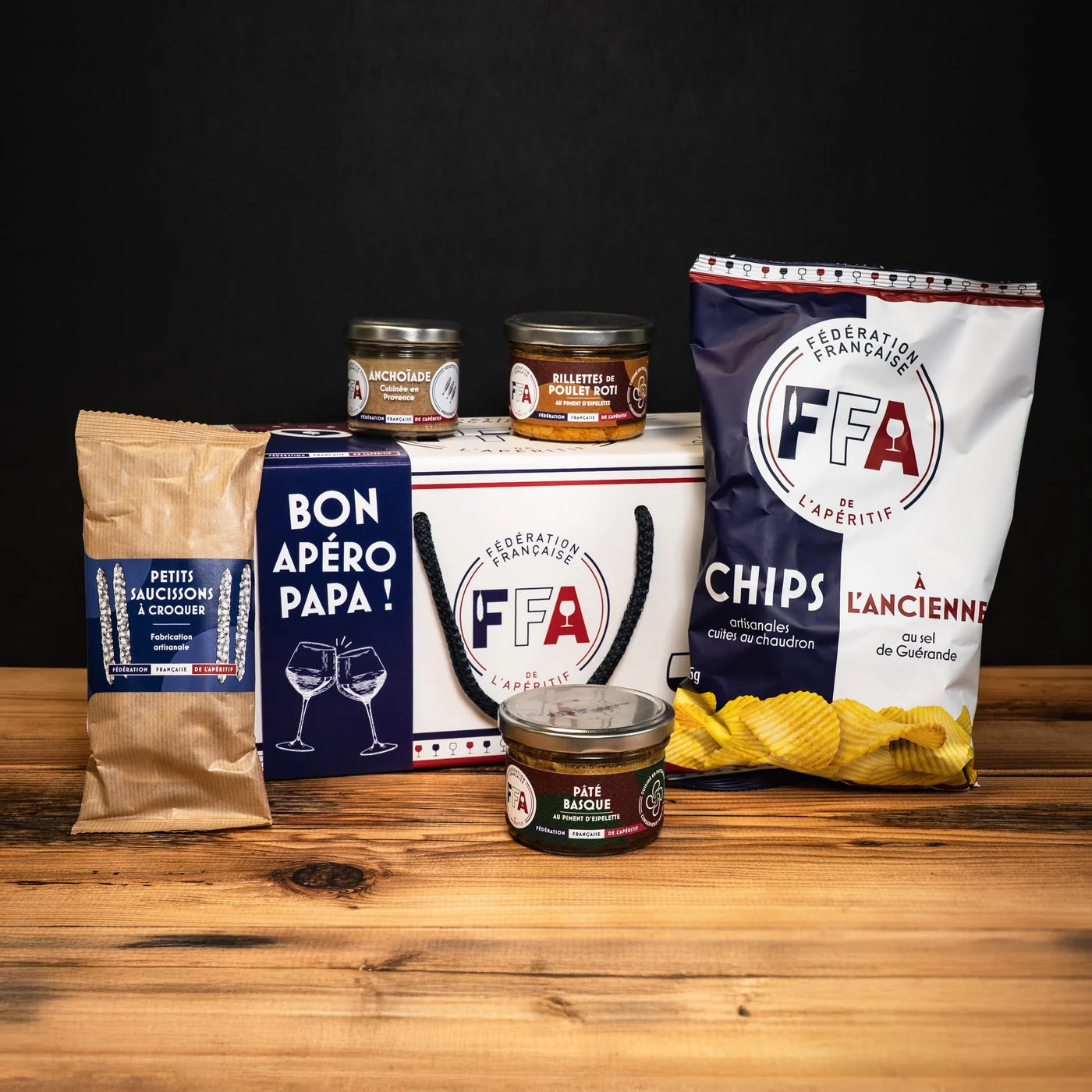 Bon apéro papa ! » de la Fédération Française de l’Apéritif, avec chips à l’ancienne, pâté basque, anchoïade, rillettes de poulet rôti et petits saucissons — une idée cadeau gourmande et conviviale pour l’apéritif.