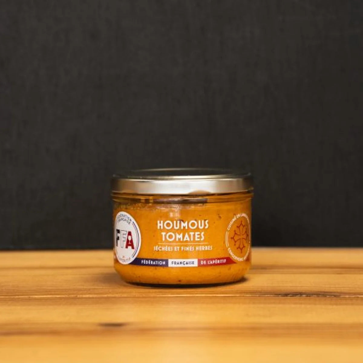 Houmous tomates séchées et fines herbes artisanal FFA, pot en verre sur planche bois, produit du Languedoc, apéritif gourmand et méditerranéen. 