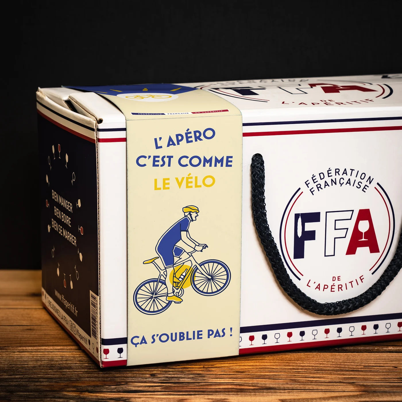 Boîte cadeau FFA “L’apéro c’est comme le vélo — ça s’oublie pas !” avec illustration cycliste.