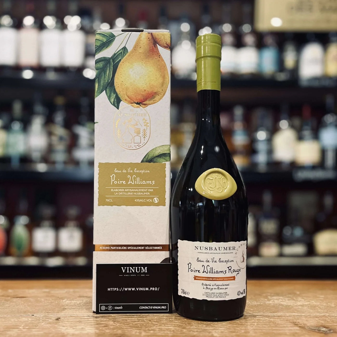 Bouteille de Poire Williams Rouge Nusbaumer avec son coffret illustré, présentée en visuel e-commerce sur fond blanc.