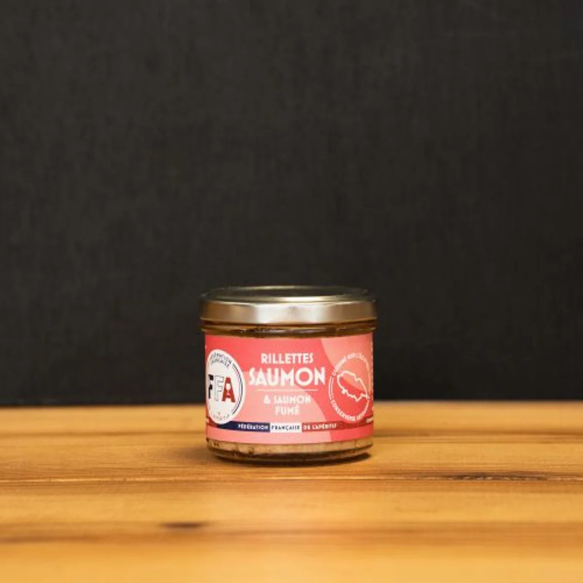 Rillettes de saumon artisanales FFA, préparées sur l’île d’Yeu avec saumon frais et fumé, présentées dans un bocal sur fond bois clair pour l’apéritif.