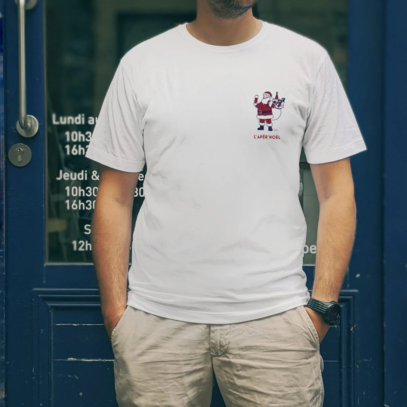 T-shirt FFA “L’Apèr’Noël” porté en extérieur devant une devanture bleue, avec illustration du Père Noël version apéritif.
