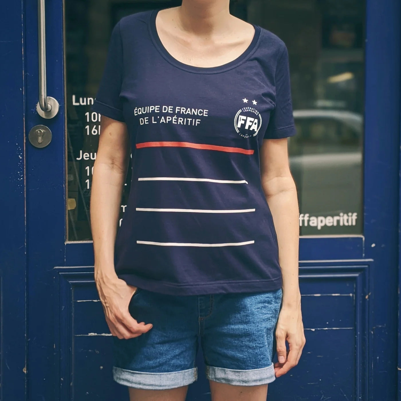 T-shirt bleu marine Équipe de France de l’Apéritif signé FFA — design tricolore élégant avec bandes blanches et rouge, porté en terrasse dans une ambiance conviviale et estivale.