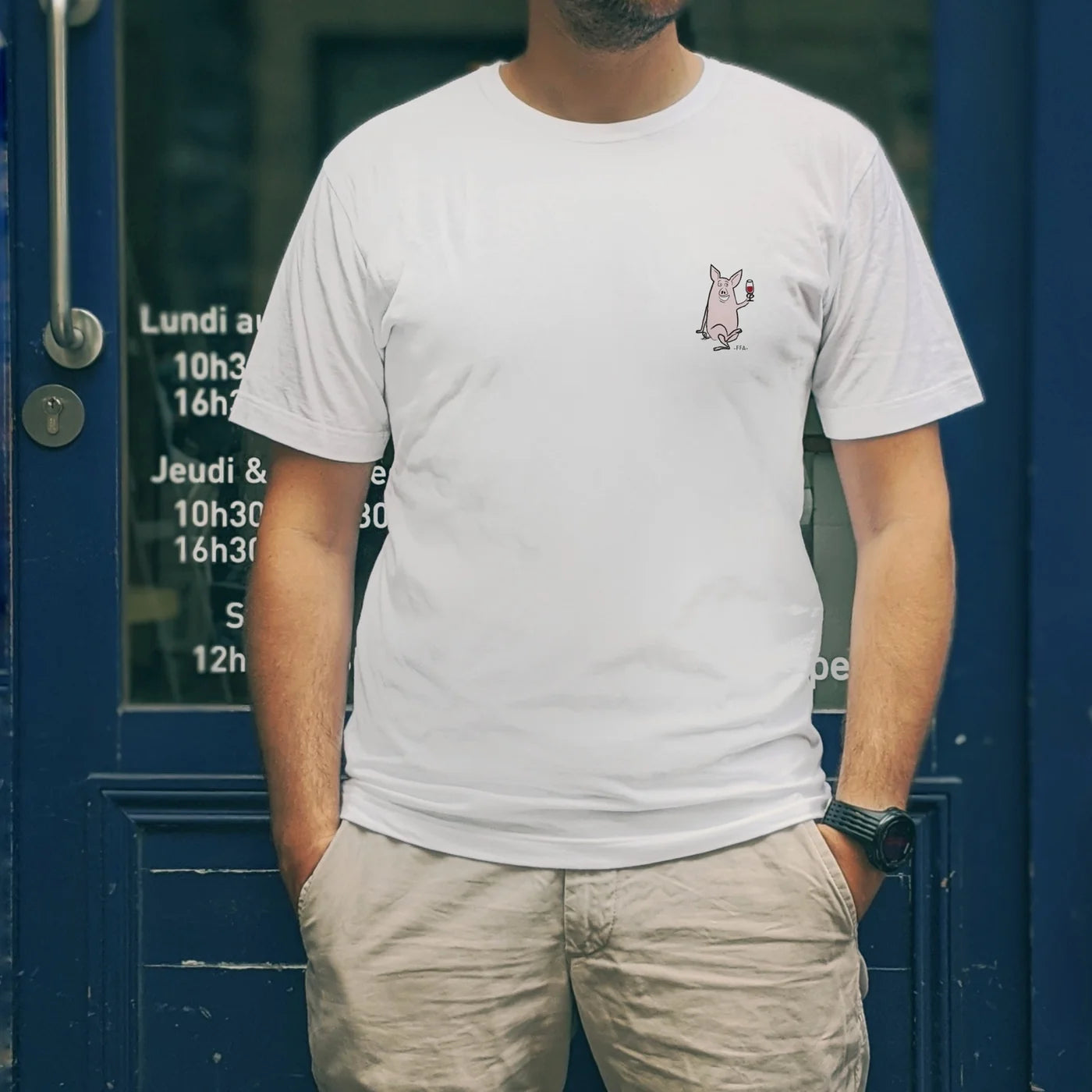 T-shirt blanc FFA “Patrick Sauisson” porté devant une devanture bleue — illustration humoristique du cochon à l’apéritif.
