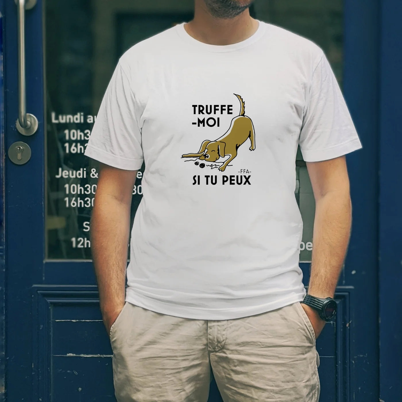 T-shirt blanc FFA “Truffe-moi si tu peux” avec illustration de chien truffier, porté devant une devanture bleue — ambiance apéritif.